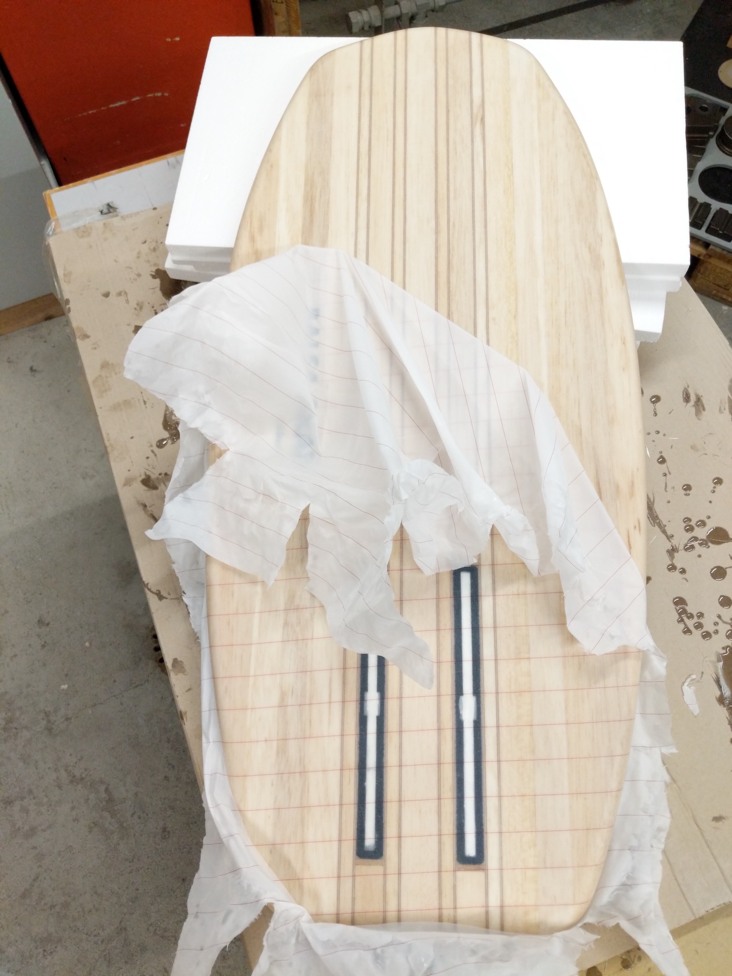 Removing the peel ply from the balsa surfboard